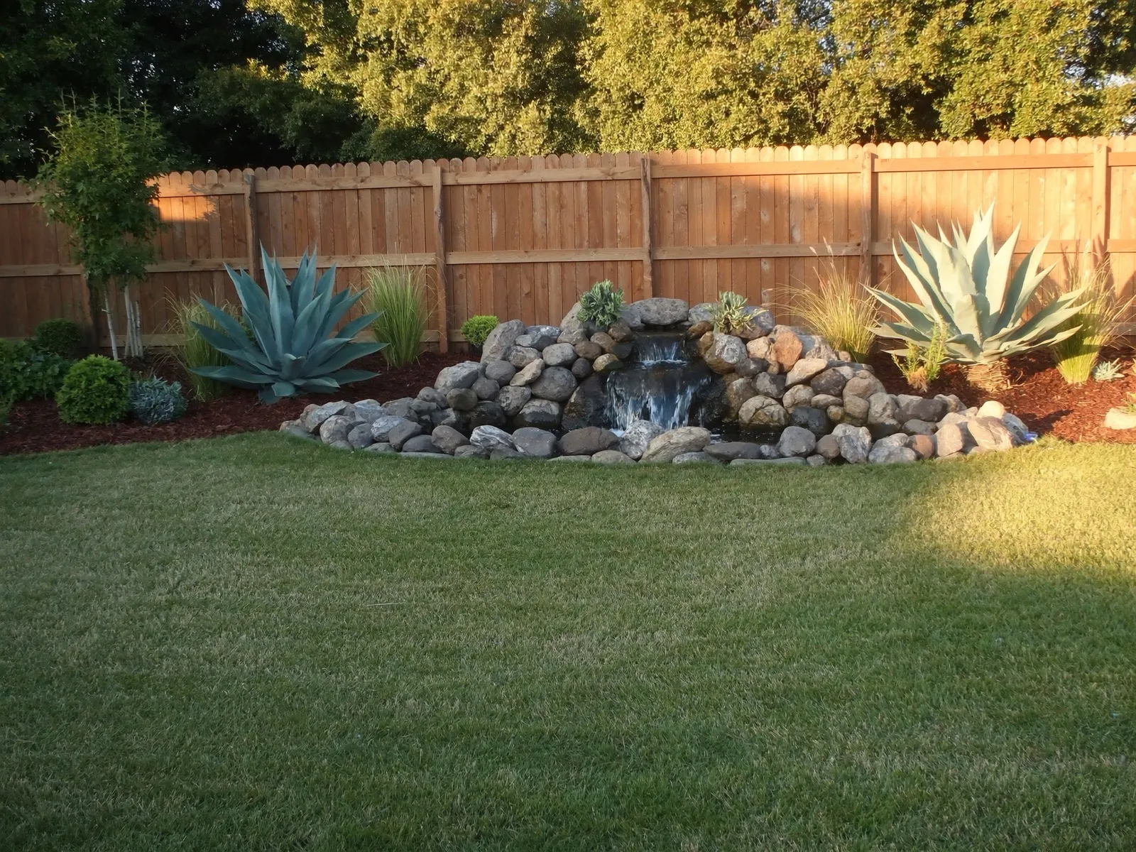 Pondless waterfall stacked from Sabine river rock with water cascading over the top stones at golden hour